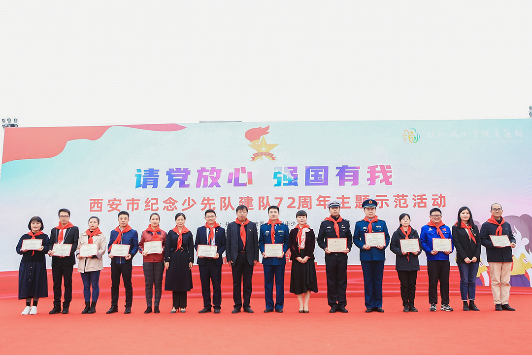 配图：与会领导为校外辅导员们颁发聘书和标志牌。.jpg